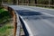 Road barriers resembling railings made of solid wooden beams and trunks, rods. inside the wooden beam is a metal structure that ab