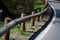 Road barriers resembling railings made of solid wooden beams and trunks, rods. inside the wooden beam is a metal structure that ab