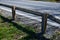 Road barriers resembling railings made of solid wooden beams and trunks, rods. inside the wooden beam is a metal structure that ab