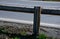 Road barriers resembling railings made of solid wooden beams and trunks, rods. inside the wooden beam is a metal structure that ab