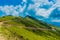 The road in the beautiful sunny mountains in summer among the fields