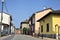 Road bordered by houses with a church at the end of it on a sunny day in a village in the italian countryside