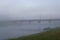 Road bridge over the river covered with predawn mist