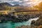 Road bridge over turquoise Katun river in Altai Mountains. Russian autumn in Siberia. Incredible landscape with a metal bridge