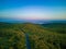 Road with cars and trucks leads into the distance between forests on the Balkan Mountains.