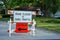 Road closed to thru traffic detour construction sign in a residential neighborhood