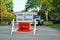 Road closed to thru traffic detour construction sign in a residential neighborhood