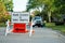 Road closed to thru traffic detour construction sign in a residential neighborhood