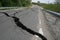 Road collapses with huge cracks. Flood damage highway. Asphalt road collapsed and fallen after heavy flood or earthquake