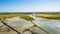 Road and colourful sand flats surrounding Le Mont Saint Michel during low tide, Normandy, Northern France