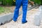 Road construction and installation of curbs in the Park, the feet of the worker in blue uniform