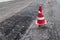 Road construction or repair - laying a new layer of asphalt, marking the level for increased accuracy and warning signs cone