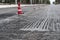 Road construction or repair - laying a new layer of asphalt, marking the level for increased accuracy and warning signs cone