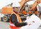 Road construction worker in front of excavator