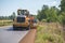 Road construction workers repairing highway road on sunny summer day