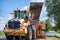 Road construction workers repairing highway road on sunny summer day