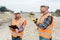 Road construction workers using measuring device on the field