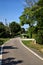 Road in the countryside in the middle of a group of country house at sunset in summer