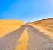 A road crossing an arid dune terrain