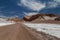 Road crossing Valle de la Luna. Dunes and rock formations covered with salt