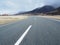 Road curving into distance and mountains in spring.