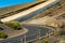 The road cut a hill on Teide volcano. Colorful volcanic soil. Desert ground