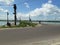 The road cuts across rice fields and electric poles