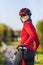 Road Cycling Ideas. Winsome Caucasian Female Cyclist In Warm Outfit Posing On Road Bike While Smiling Turned Backwards Outdoors