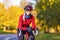 Road Cycling Ideas. Winsome Female Cyclist In Warm Outfit Posing On Road Bike While Smiling And Getting Ready For Start Outdoors