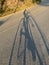 Road cyclist shadow on road climbing a mountain