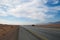 Road through the desert landscape. several cars are driving along the highway in the desert