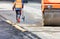 A road engineer working on the road takes measurements of the road with an electronic measuring wheel