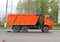 Road equipment on the street of the city in Russia. Russian truck `Kamaz` dump truck orange with body and cabin, with three axle