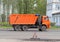 Road equipment on the street of the city in Russia. Russian truck `Kamaz` dump truck orange with body and cabin, with three axle