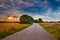 Road in the field at sunset. Summer field. Asphalt road. Summer landscape. Russian roads