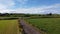 A road between fields. Blue sky over grass fields. Irish summer landscape. Green grass field under blue sky