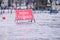 Road flood closed sign under deep water during bad extreme heavy rain storm weather in UK