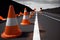 road with fresh asphalt layer and traffic cones to direct drivers to slow down