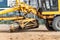 Road grader at the construction site. Powerful construction machine for ground leveling and excavation. Close-up. Professional