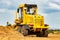 Road grader at the construction site. Powerful construction machine for ground leveling and excavation. Close-up. Professional