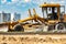 Road grader at the construction site. Powerful construction machine for ground leveling and excavation. Close-up. Professional