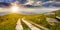 Road on a hillside near mountain peak at sunset