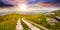 Road on a hillside near mountain peak at sunset