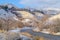 Road and homes on sunlit snowy mountain in winter