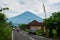 The road with houses in Amed. Views of mount Agung in cloudy weather. Bali