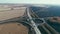 Road junction under construction. Trucks and cars drive along the highway in the fall. Transport connection. Top view on