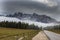 Road from Lake Misurina between the mountains of the Italian Dolomites to Cortina. The mountains are in the fog and there are