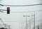 Road landscape with red traffic lights ,street lamp and hight voltage power cable on sky background while raining