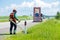 Road landscapers cutting grass around mileposts