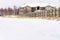 Road with layer of fresh white snow in winter with homes in the background